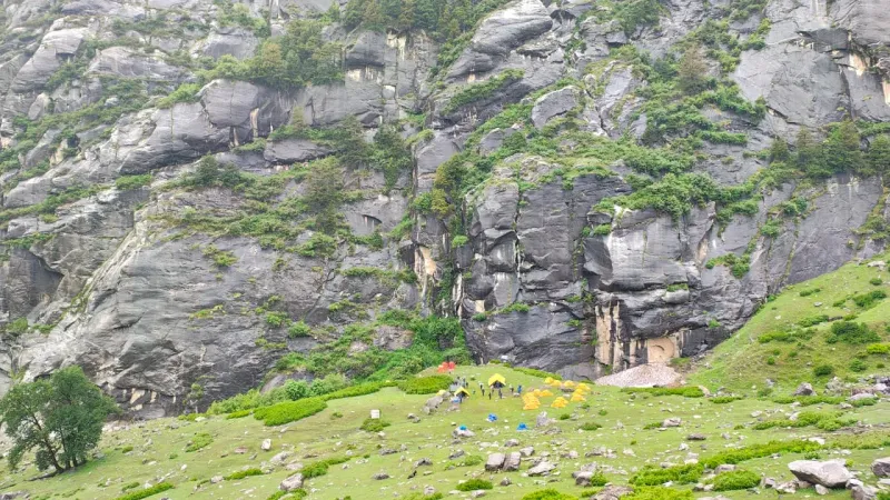 Campsite dwarfed by massive rock faces reminding you how small you are here | © MountRoutes
