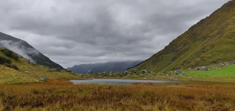The serene Ruinsara Tal lake, a key highlight on the Bali Pass trek before the high-altitude climb. | © MountRoutes